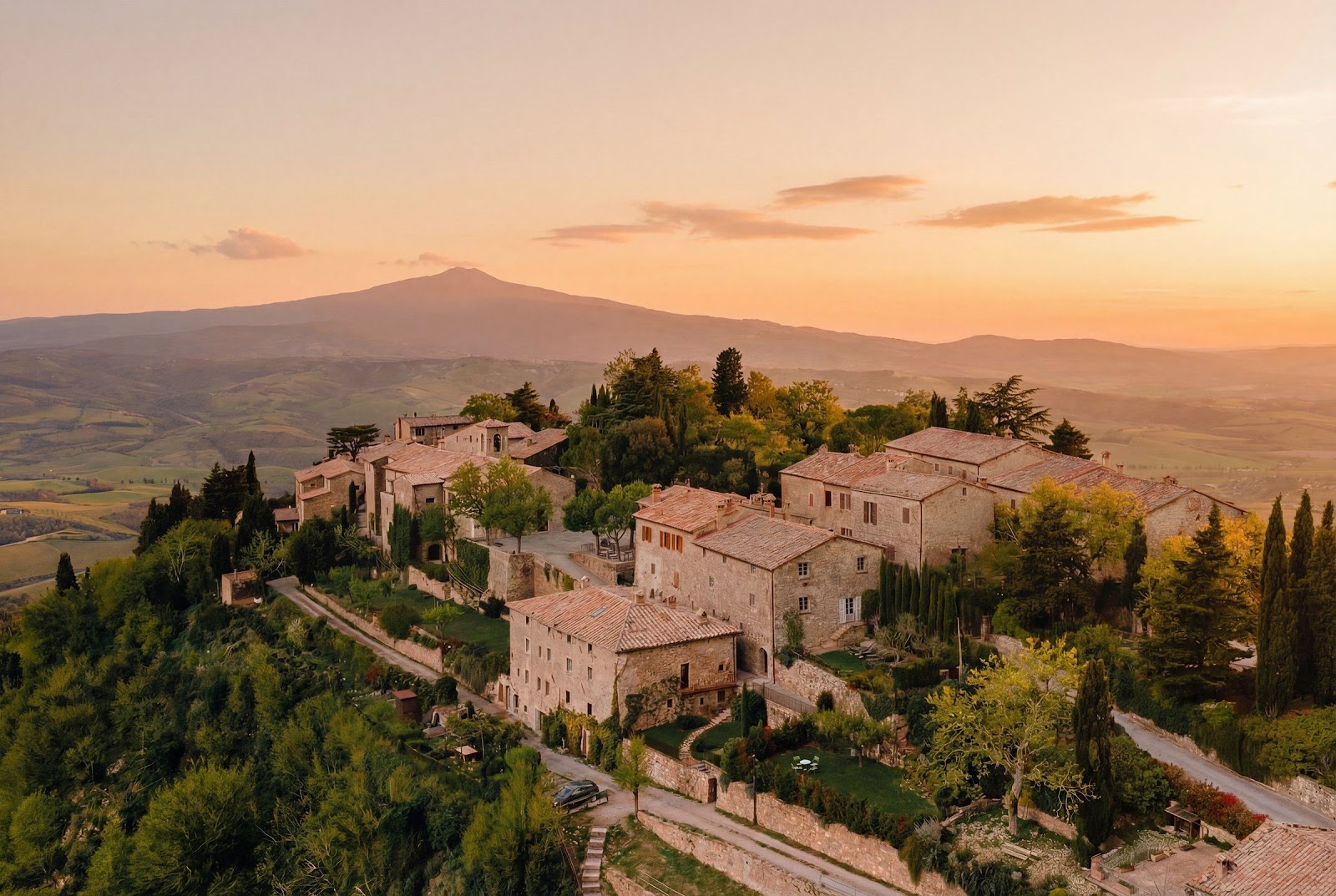 A Tuscan hill village at dusk with Monte Amiata rising behind the Val d&rsquo;Orcia