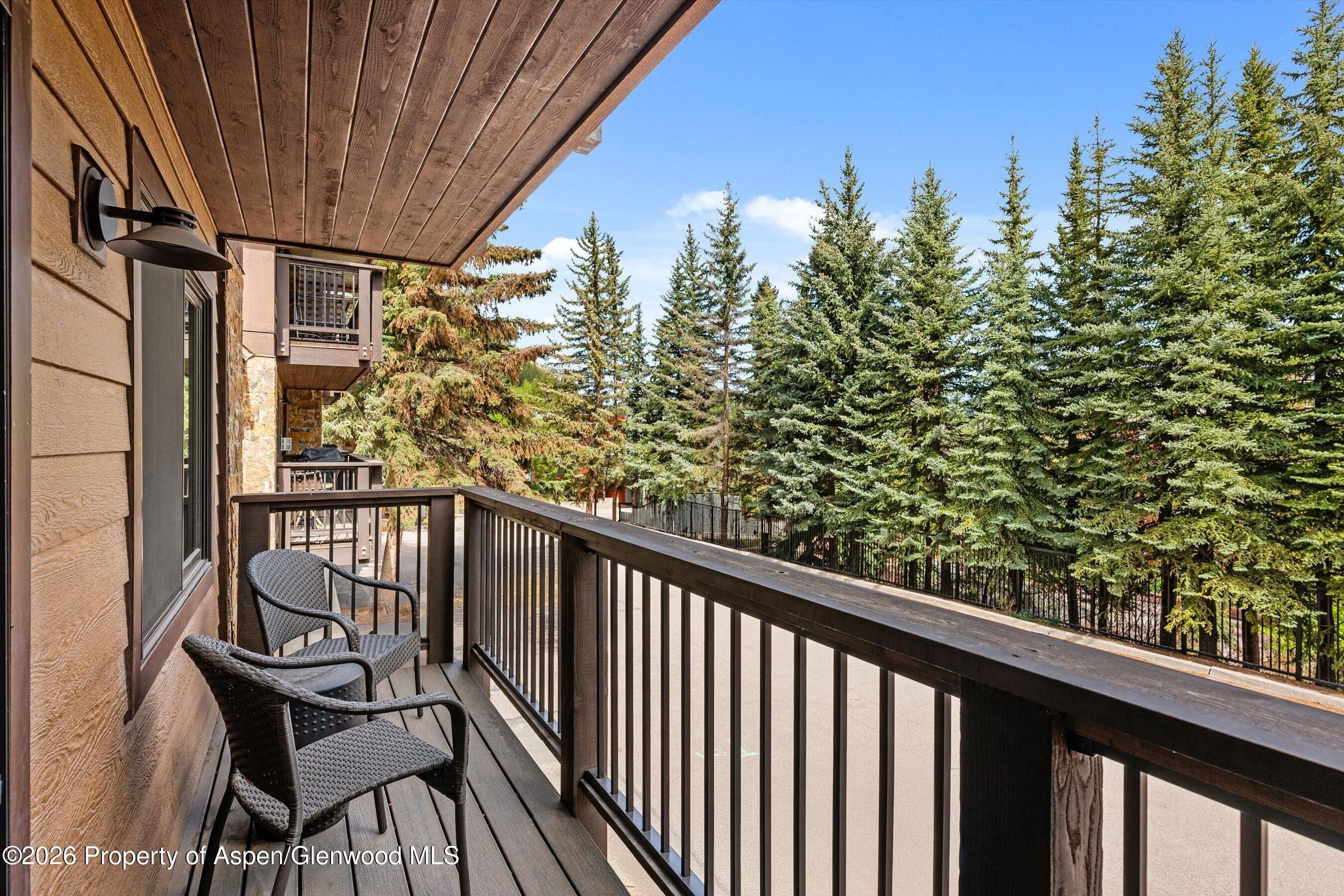 Balcony of the Aspen townhome looking towards pine trees and the mountain