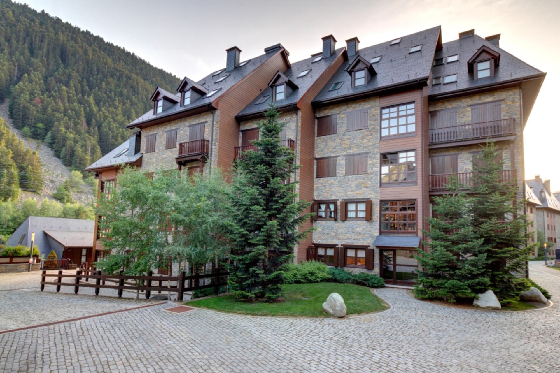An apartment building in Val d'Aran in summer, mountains behind