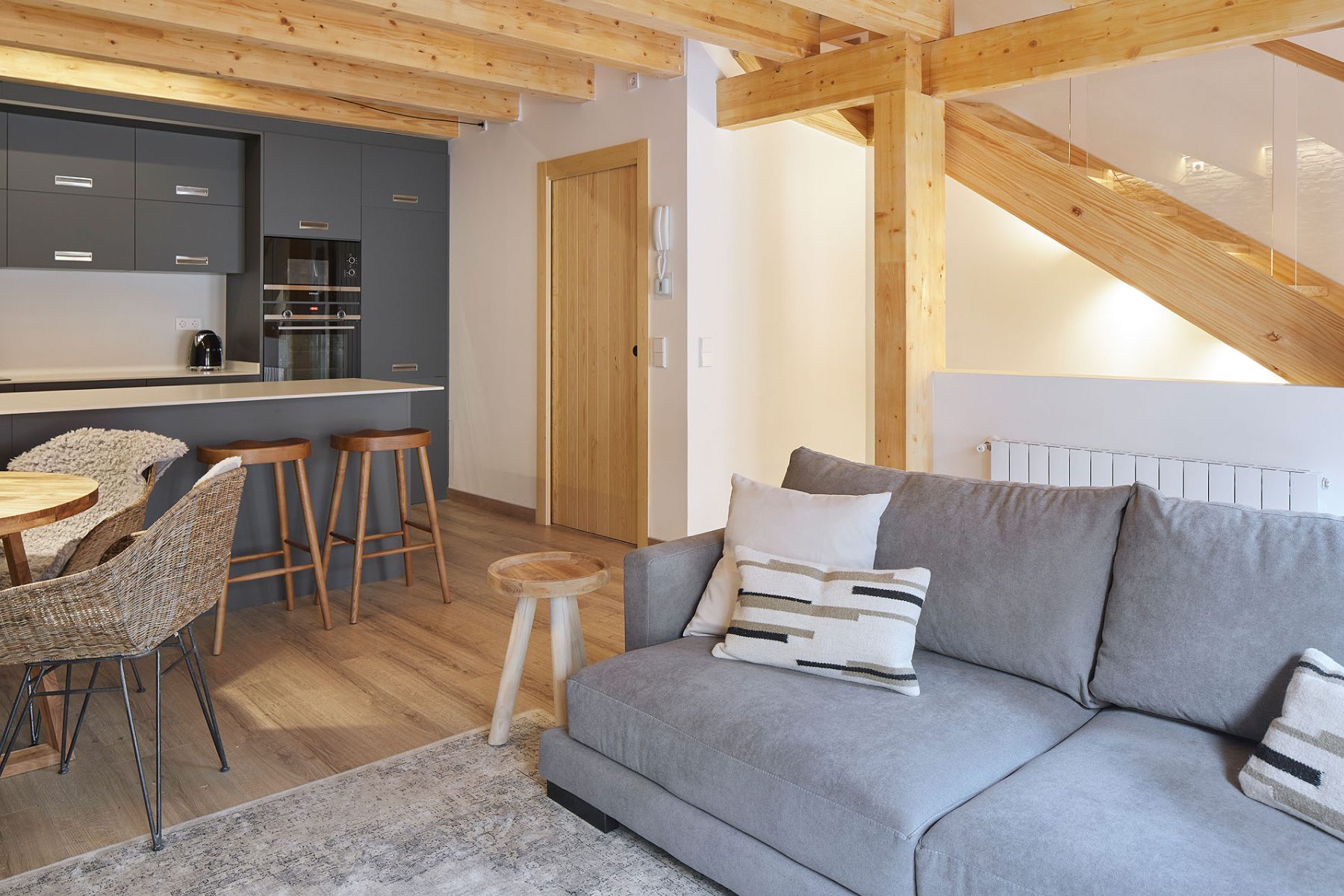 An open-plan living room with timber beams in a Baqueira chalet