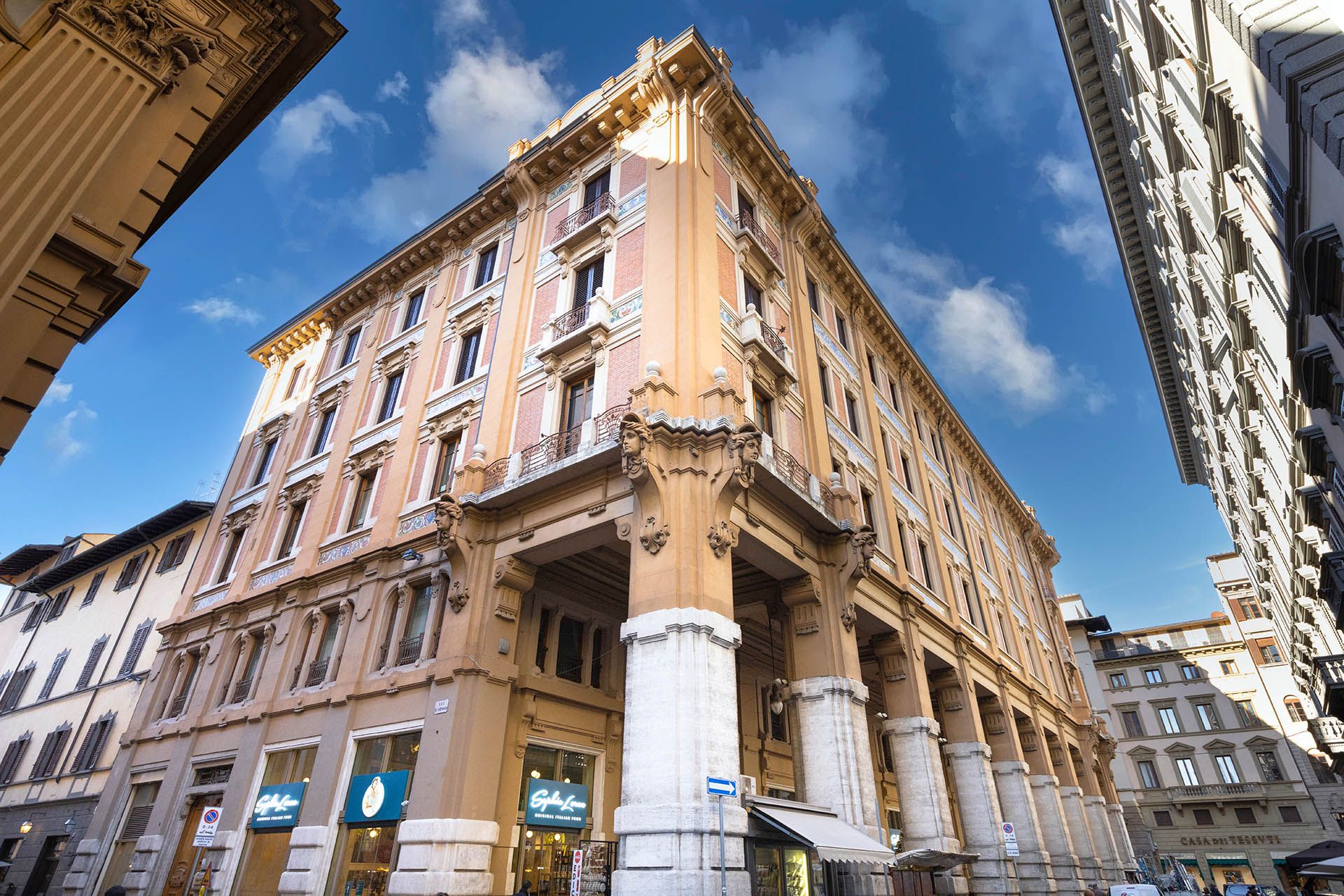 The stone facade of a historic palazzo on a street in central Florence