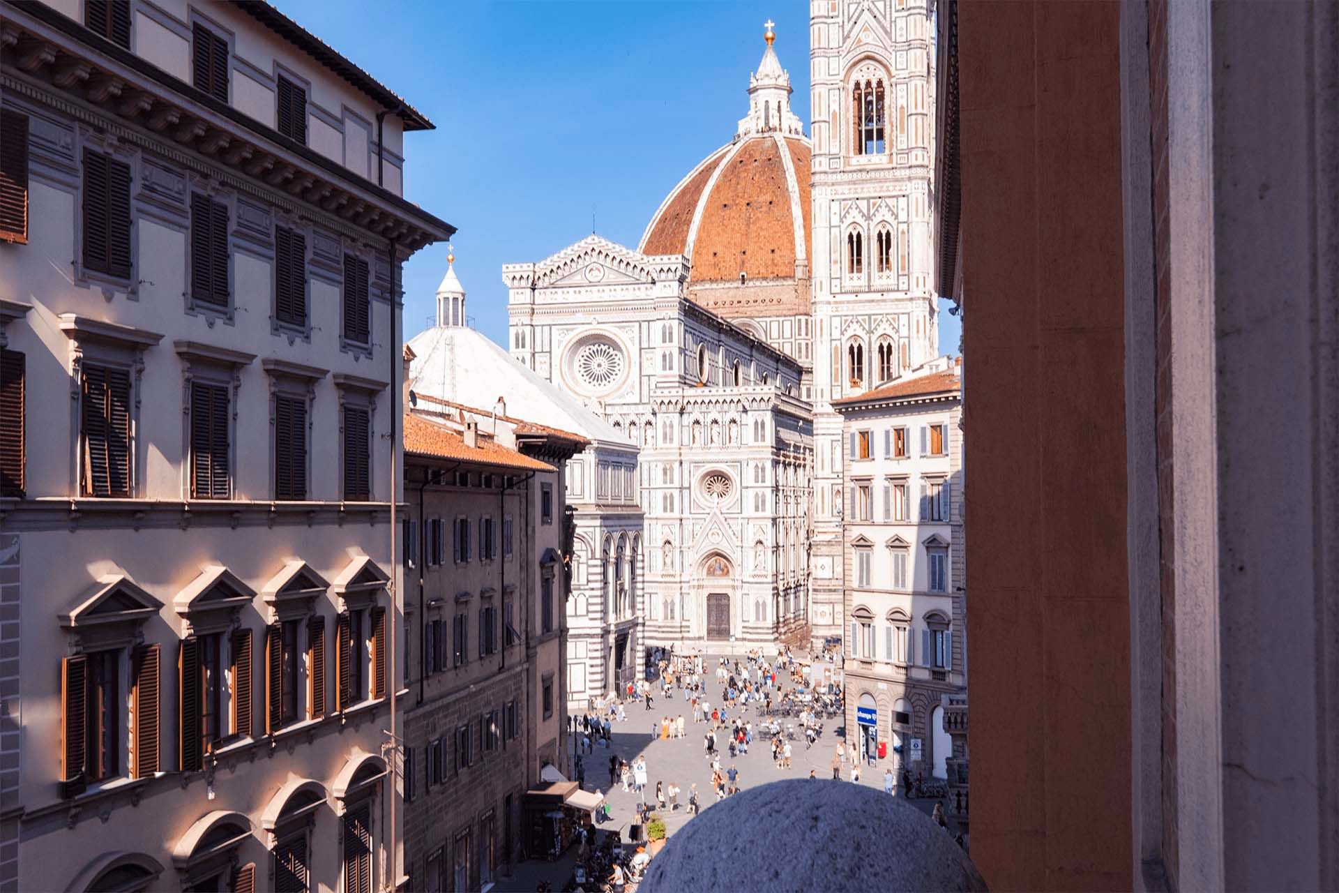 The dome and campanile of Florence cathedral framed by the open shutters of an apartment window