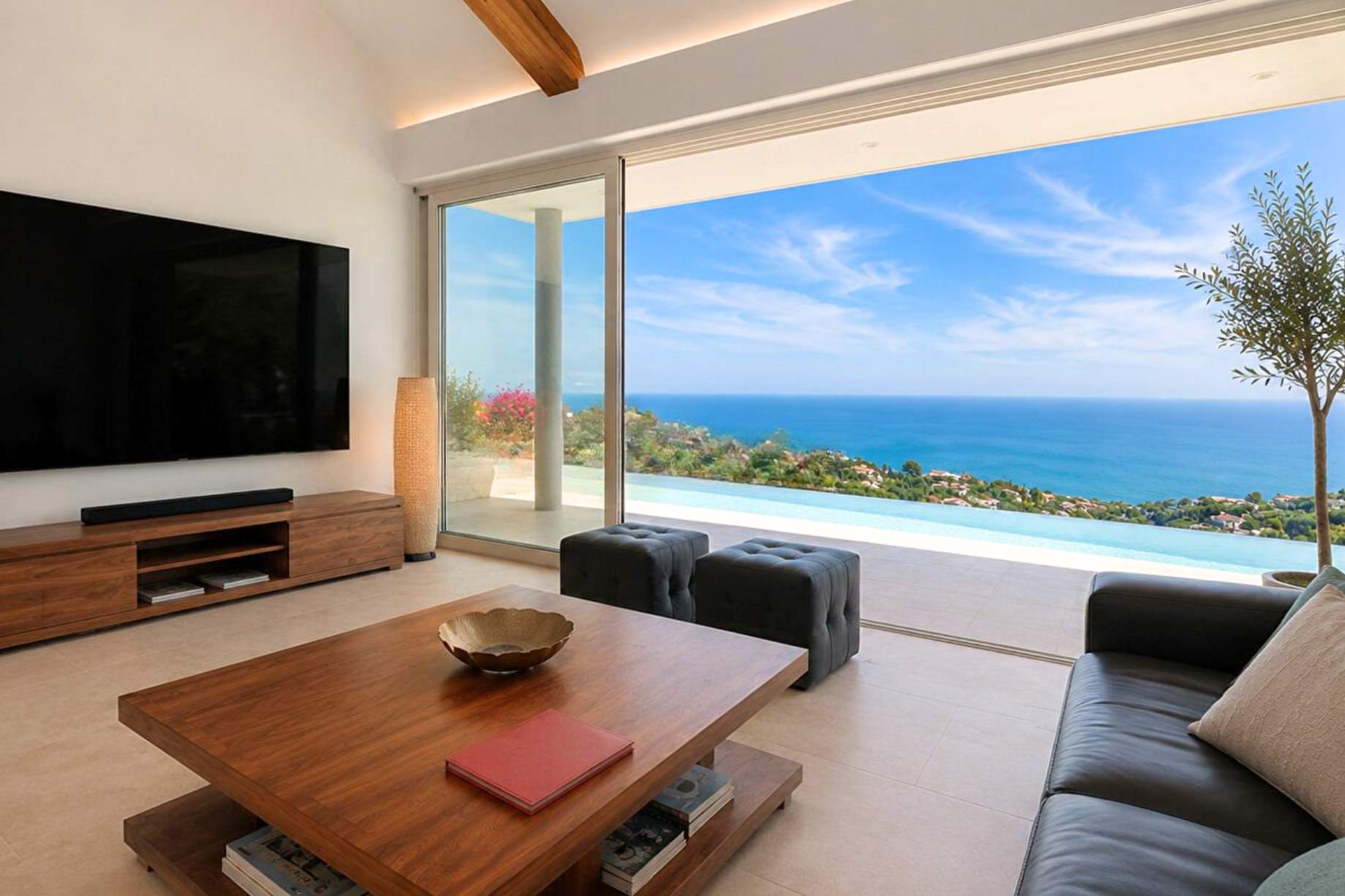 A living room at Les Issambres opening onto an infinity pool and the sea